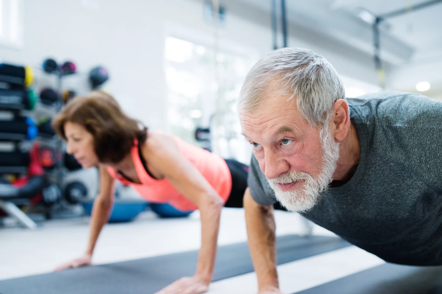An older couple exercising together in a gym — the patients and longevity Gen7 Health is built around